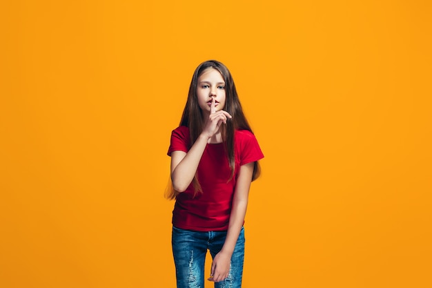 The young teen girl whispering a secret behind her hand