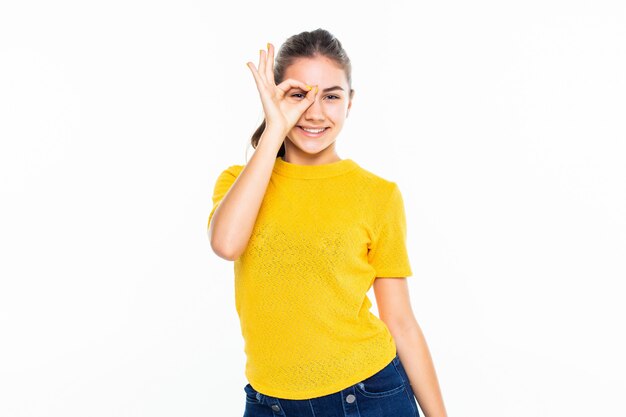 Young teen girl with fun okay gesture isolated on white wall