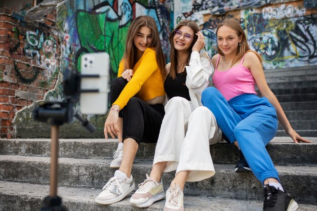 Young teenage girls recording reels of themselves outdoors for social media