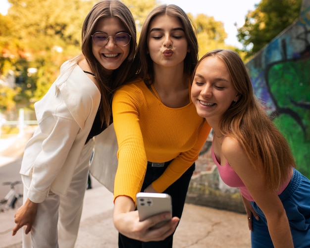 Young teenage girls recording reels of themselves outdoors for social media