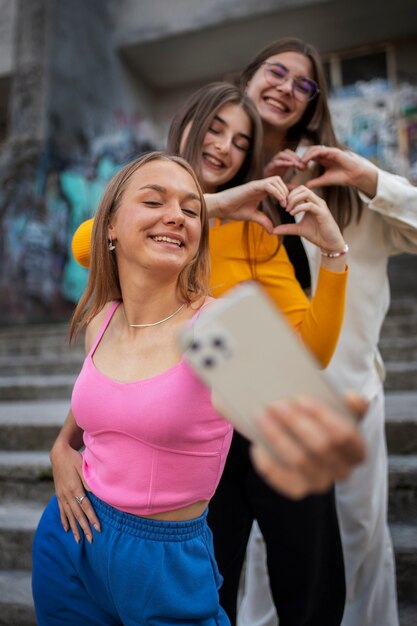 Young teenage girls recording reels of themselves outdoors for social media