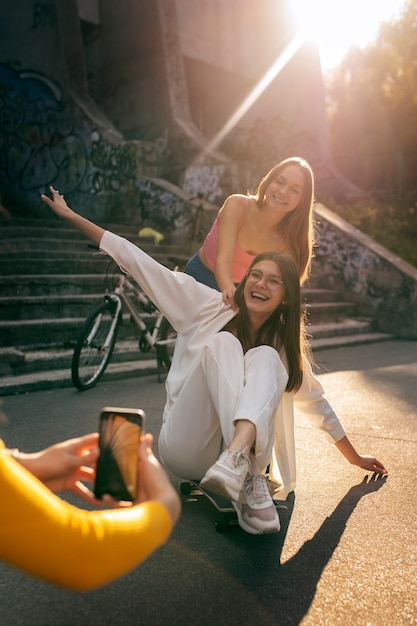 Young teenage girls recording reels of themselves outdoors for social media