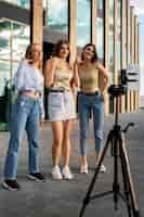 Foto gratuita giovani ragazze adolescenti che registrano bobine di se stesse all'aperto per i social media