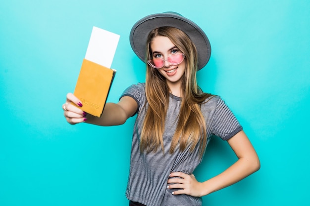 Free photo young teenage lady holds her passport documents with ticket in her hands isolated on green studio wall