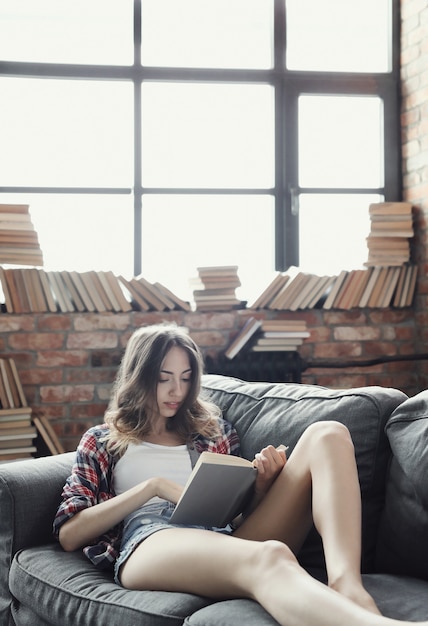 Free photo young teenager girl reading a book at home