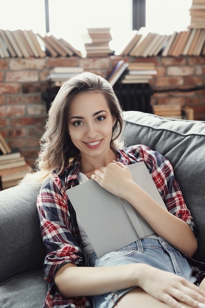 Young teenager girl reading a book at home