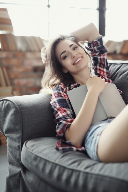 Young teenager girl reading a book at home