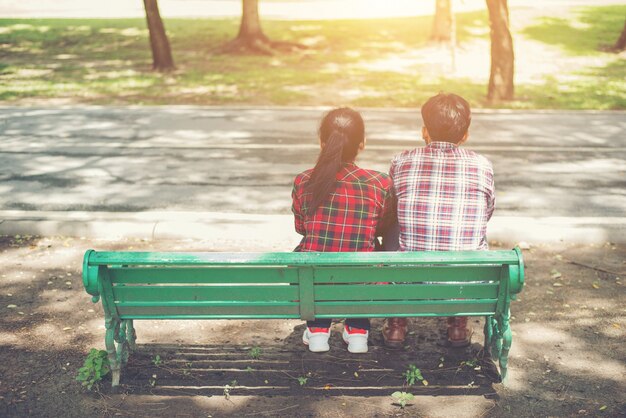 でベンチに一緒に座って恋に若い十代のカップル