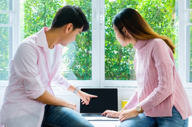 Young teenagers working with laptop together