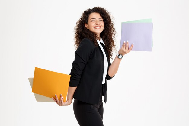 Young tender curly girl holding documents