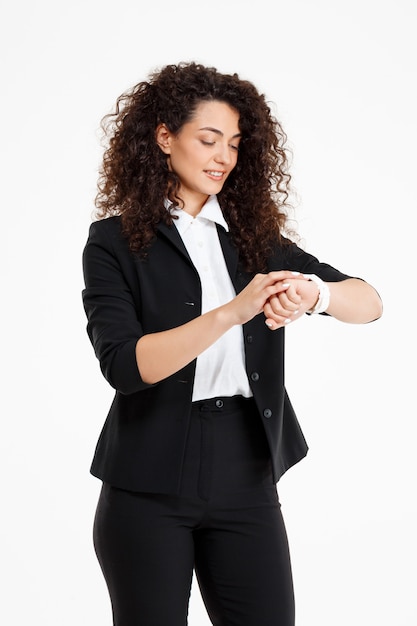 Young tender curly girl looking at watch