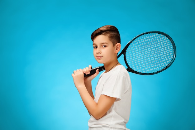 파란색 벽에 젊은 테니스 선수.