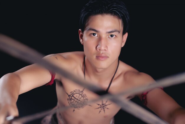 剣との戦いの姿勢でポーズをとって若いタイ男性戦士