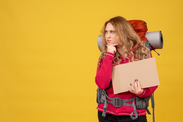 Young thoughtful travelling girl collecting her luggage showing free space for writing