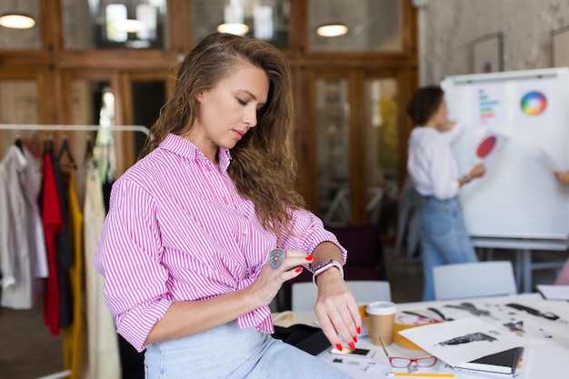 Young thoughtful woman in striped shirt and denim skirt with big