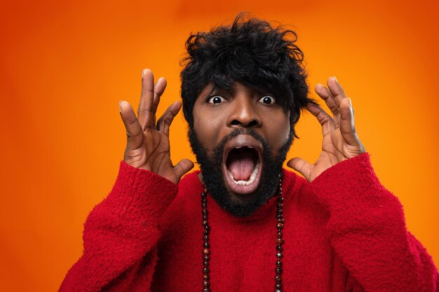 Young thrilled casual black man screaming on yellow background