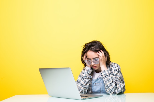 Free photo young tired woman in front of a laptop isolated