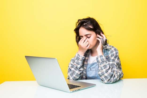 Free photo young tired woman in front of a laptop isolated