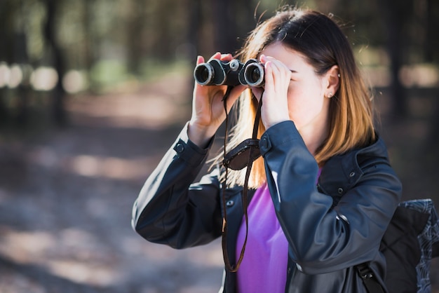 Young tourist using binoculars