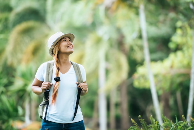 Young tourist woman with backpack enjoy nature looking away. 