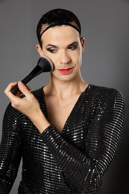 Young transgender person using a make-up brush