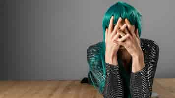 Free photo young transgender person wearing green wig copy space