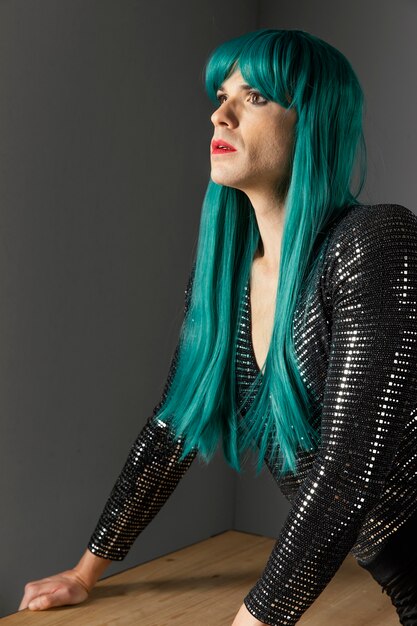 Young transgender person wearing green wig side view