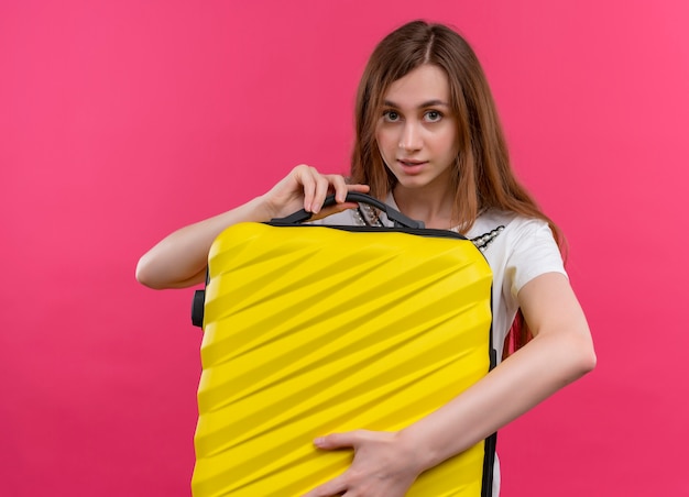 Foto gratuita ragazza giovane viaggiatore con la valigia e guardando il muro rosa isolato