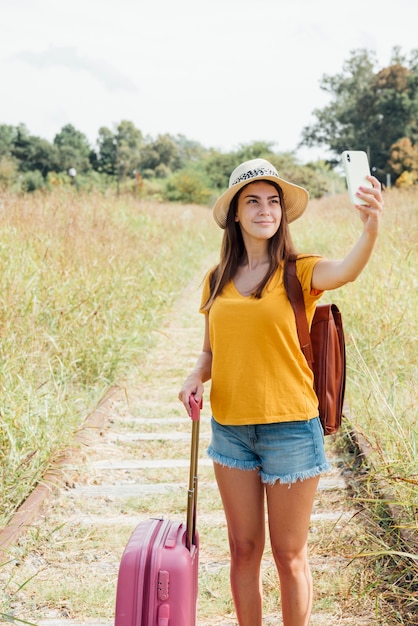 無料写真 selfieを取って荷物を持つ若い旅行者