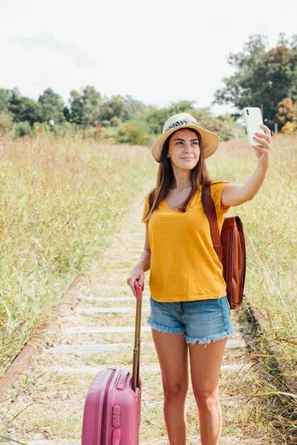 Young traveler with luggage taking a selfie