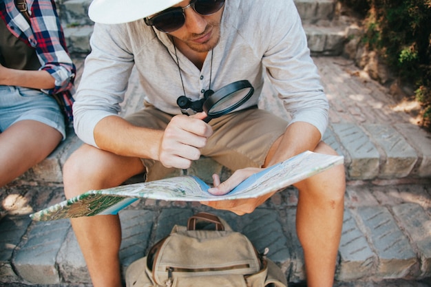 Free photo young traveler with map and loupe