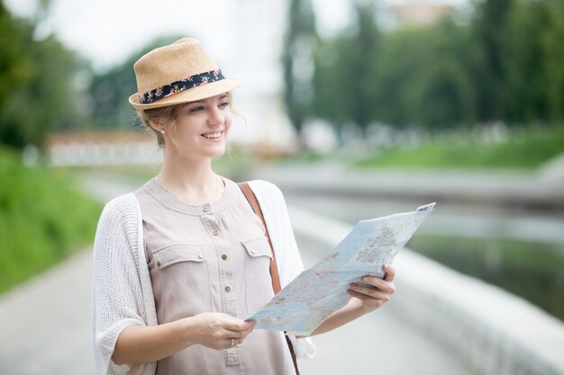 Young traveler woman checking out sights on map