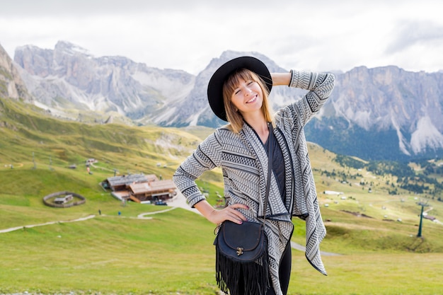 Young traveler woman with hat and backpack enjoying amazing mountain view