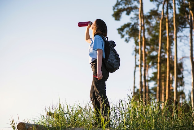 Young traveller drinking from thermos