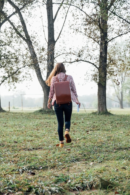 Free photo young traveller walking into the woods