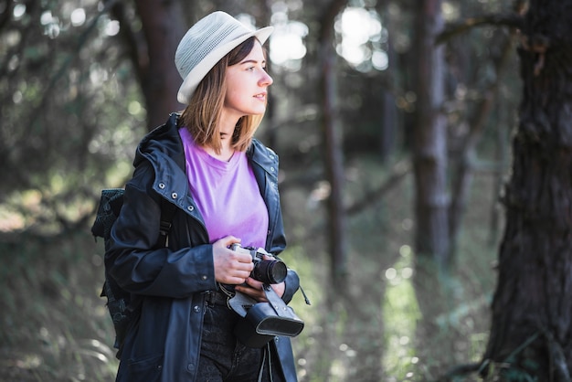 Young traveller with camera looking away