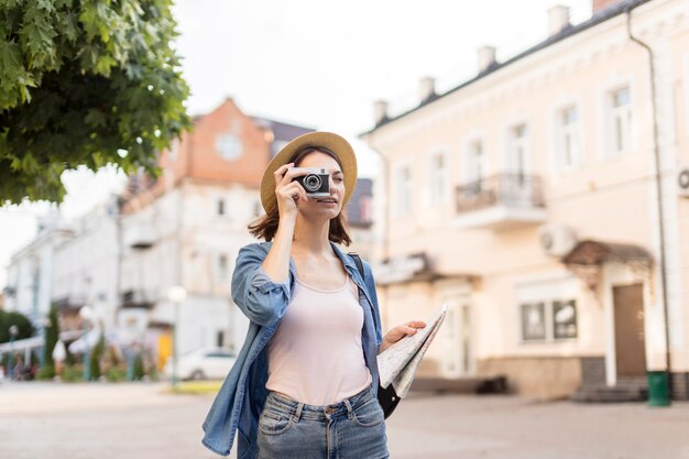 Young traveller with hat taking pictures