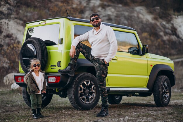 Young trendy father with his little daughter having fun by the car