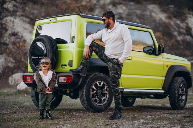 Young trendy father with his little daughter having fun by the car