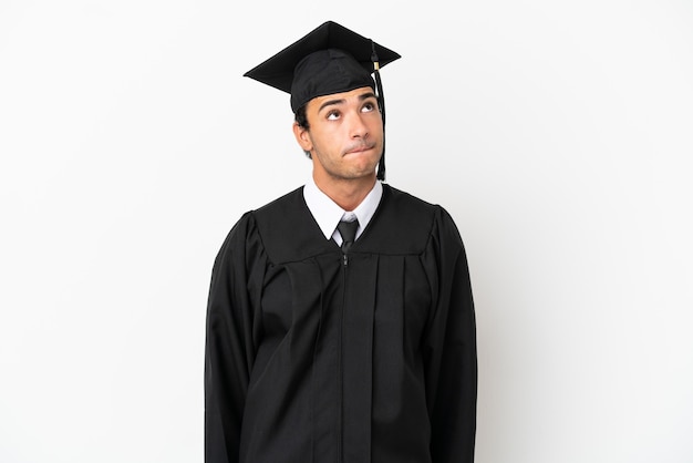 Молодой выпускник университета на изолированном белом фоне и глядя вверх