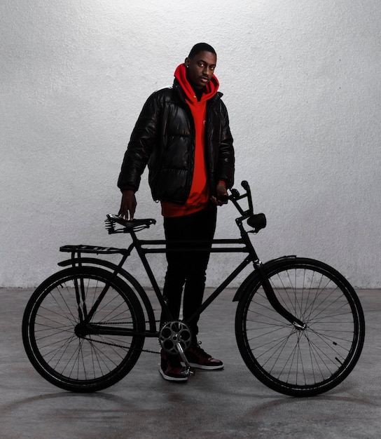 Free photo young urban man walking with his bike