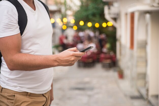 Free photo young urban professional man using smart phone. businessman holding mobile smartphone using app texting sms message