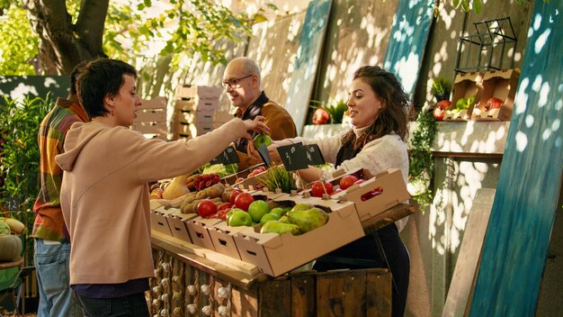 顧客に無料のリンゴのサンプルを贈る若い売り手