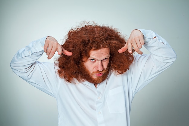 Free photo young vexed man with long red hair