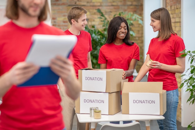 Free photo young volunteers in red tshirts at work in a distribution point