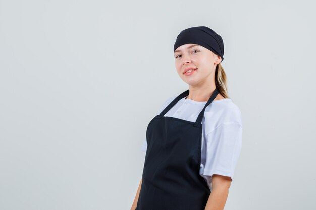 Young waitress looking in uniform and apron and looking cheerful