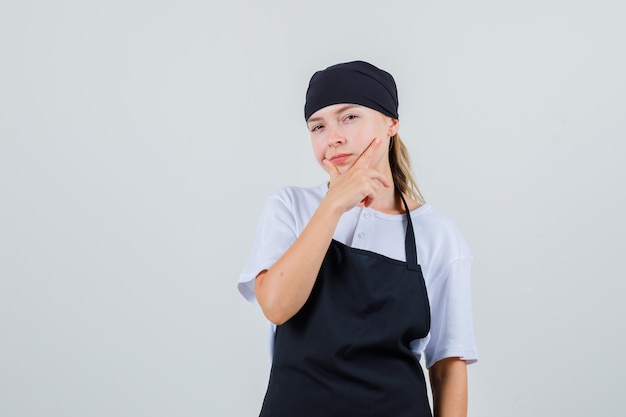 Young waitress looking in uniform and apron and looking pensive