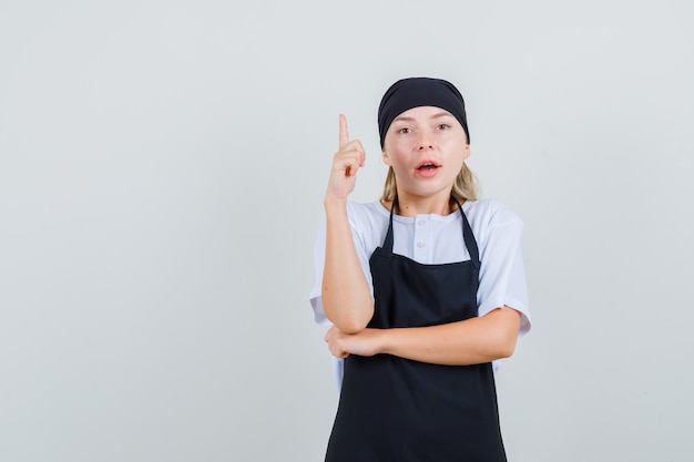 制服とエプロンで上向きの若いウェイトレス