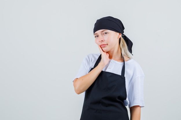 制服とエプロンで歯痛に苦しんでいる若いウェイトレス