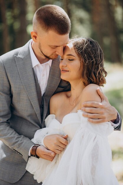 Young wedding couple having photoshoot in forest